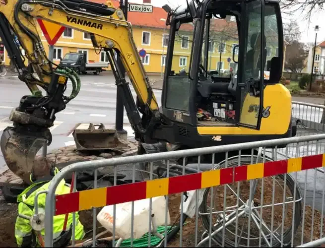 Grävmaskin och medarbetare vid ett avspärrat fiberarbete i Värnamo